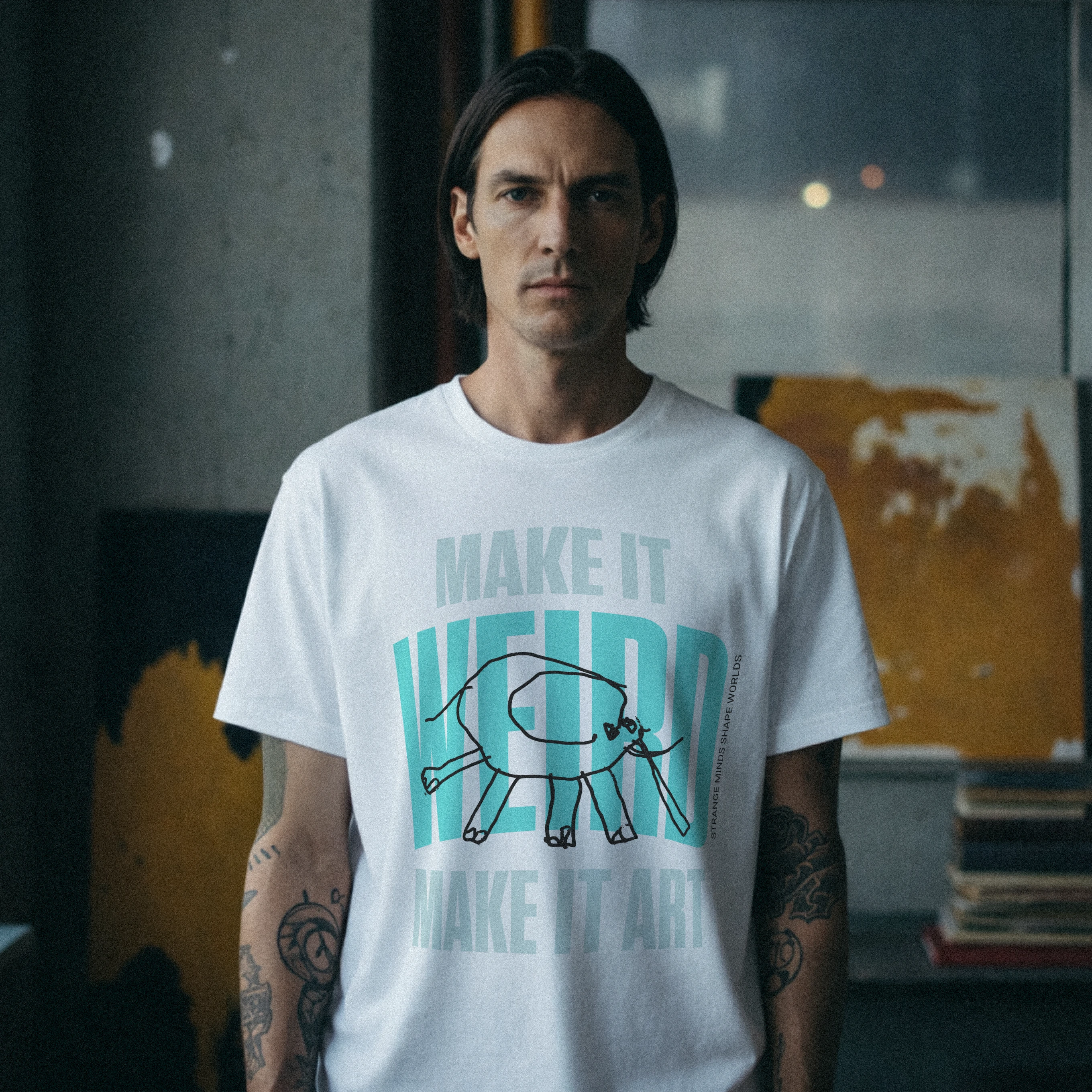 Mężczyzna w białym T-shircie „MAKE IT WEIRD, MAKE IT ART”